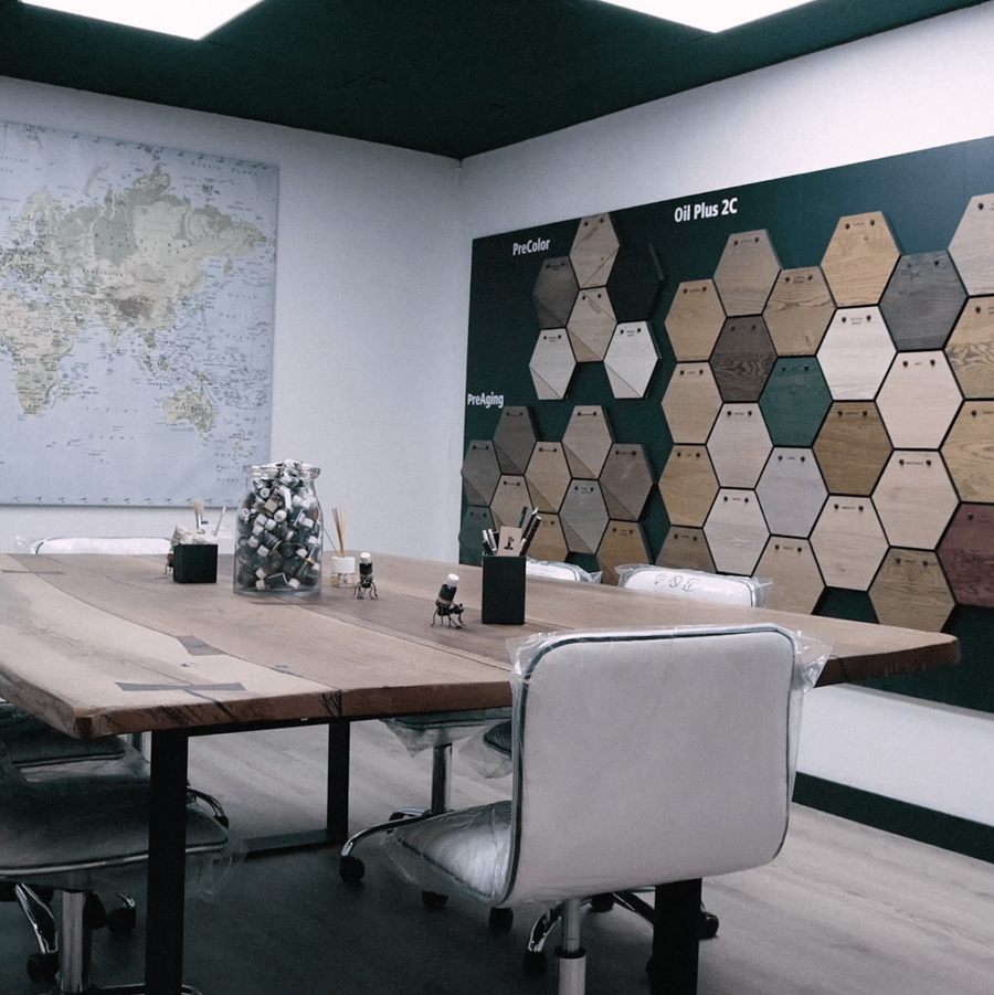 Showroom de Rubio Monocoat con mesa de roble y panel de muestras de acabados